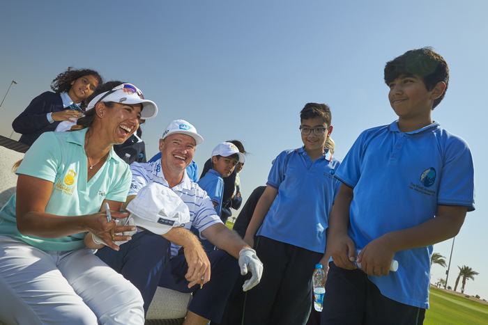 Maha Haddioui and Ernie Els sign caps for visiting kids at Royal Greens Golf and Country Club