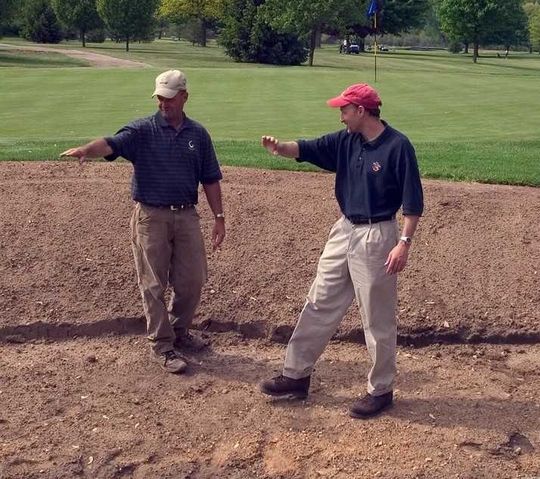 Paul Albanese (right) discusses the shape of a greenside bunker with a colleague.